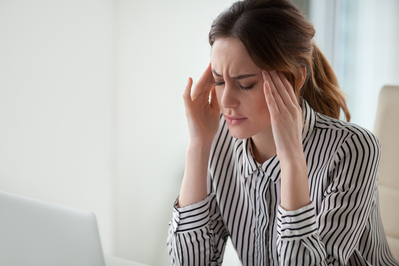 woman rubbing her temples trying to relieve migraine pain