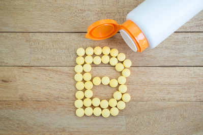 yellow pills poured out on the table in the shape of the letter "B"