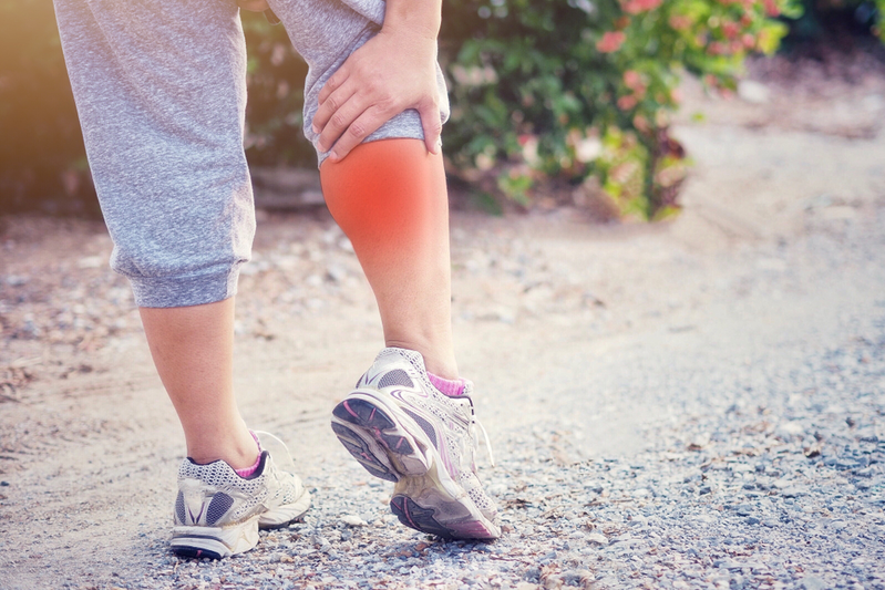 runner holding the back of her leg from muscle soreness