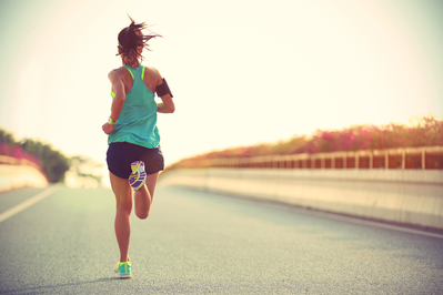 woman running on roadside at sunset