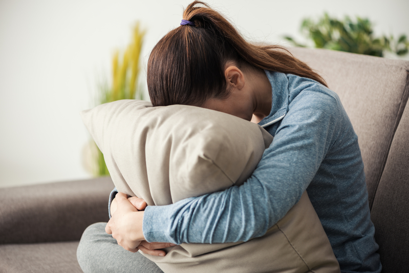 young female burying her head in a pillow