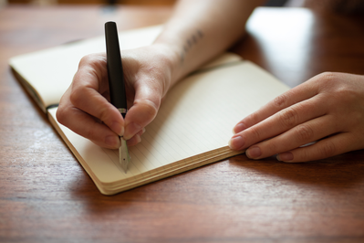 female writing down her thoughts in a journal