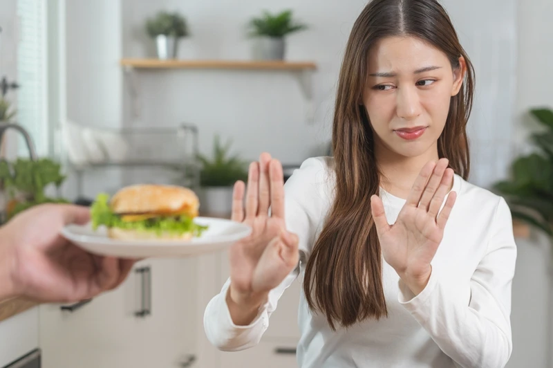 woman rejecting burger