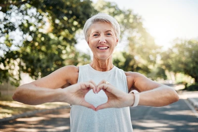 woman holding hands in heart shape